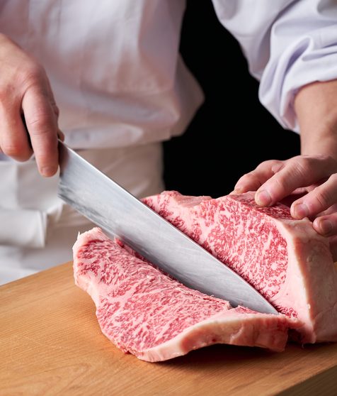 牛肉を切り分ける飲食店のスタッフ
