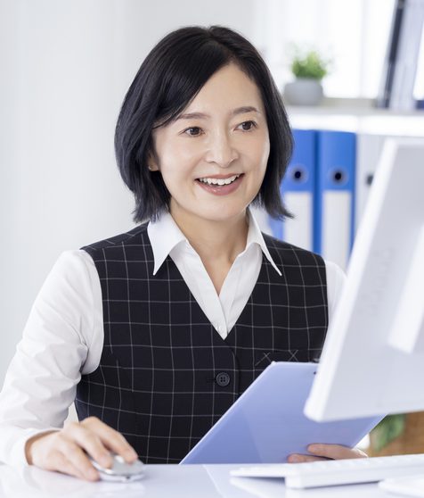 書類を手にオフィスで働く女性スタッフ