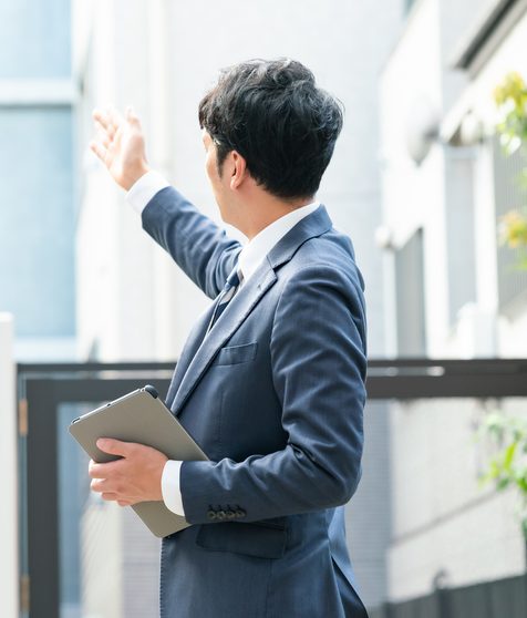 スーツ姿で案内をする営業スタッフ
